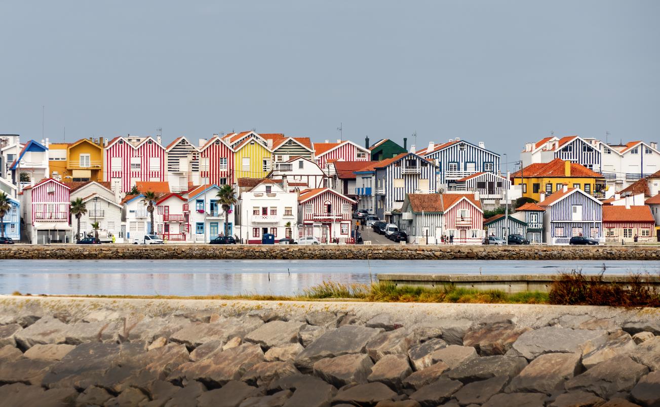 Colorful striped houses in Costa Nova, Portugal along the waterfront.